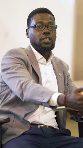 Nana-Yaw Andoh sitting in a chair.